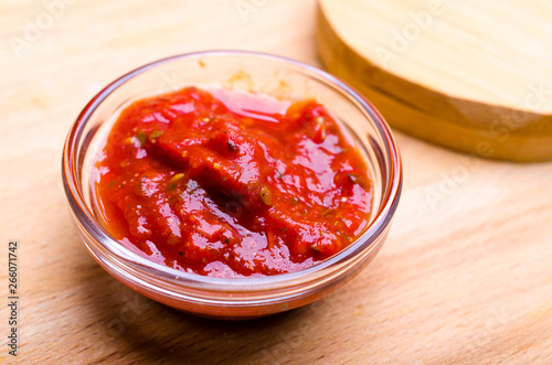 glass sauceboat with ketchup on wooden table