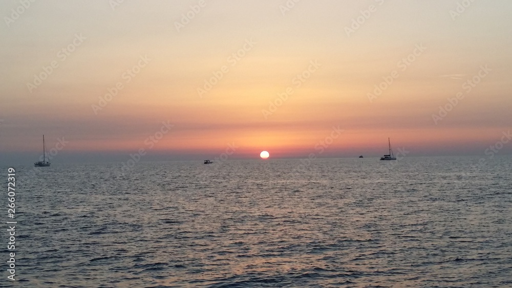 tramonto sul mare con barche sullo sfondo