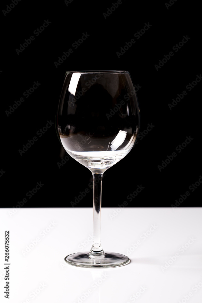 Red wine on a wineglass over a dark solid black background