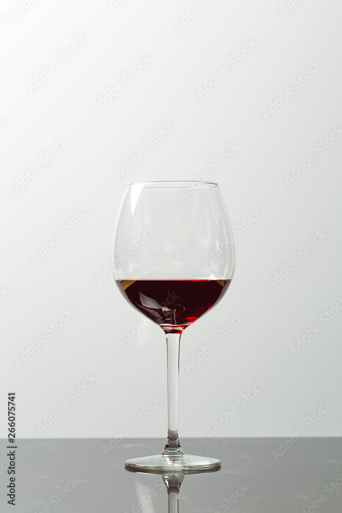Red wine on a wineglass on a white background close up still