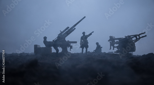 Obraz na plátně An anti-aircraft cannon and Military silhouettes fighting scene on war fog sky background