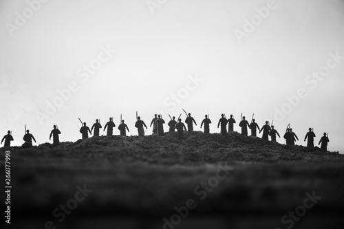 War Concept. Military silhouettes fighting scene on war fog sky background, World War Soldiers Silhouettes below Cloudy Skyline at sunset. Attack scene. Armored vehicles. © zef art