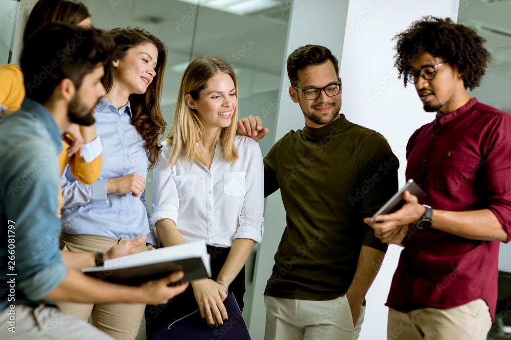 Multiethnic group of young people standing in the modern office and brainstorming Multiethnic group of young people standing in the modern office and brainstorming