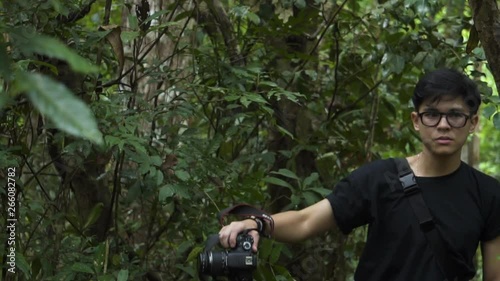 Good looking asian guy passing through the forest. Pang Sida National Park. Sakeao, Thailand. photo