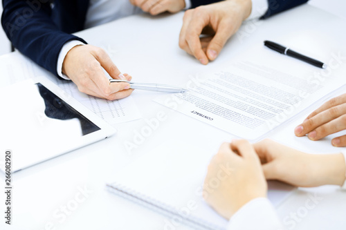 Group of business people and lawyers discussing contract papers sitting at the table, close-up. Successful teamwork, cooperation and agreement concepts