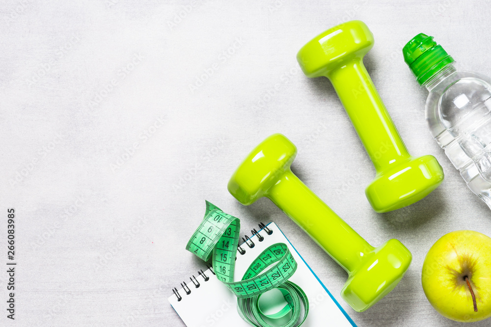 Dumbbells, measuring tape, water and apple top view. Dumbbells, measuring tape, water and apple top view.