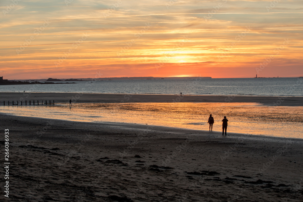 St Malo, France - September 15, 2018: Romantic walk of people before sunset on the picturesque beach of Saint Malo. Brittany, France