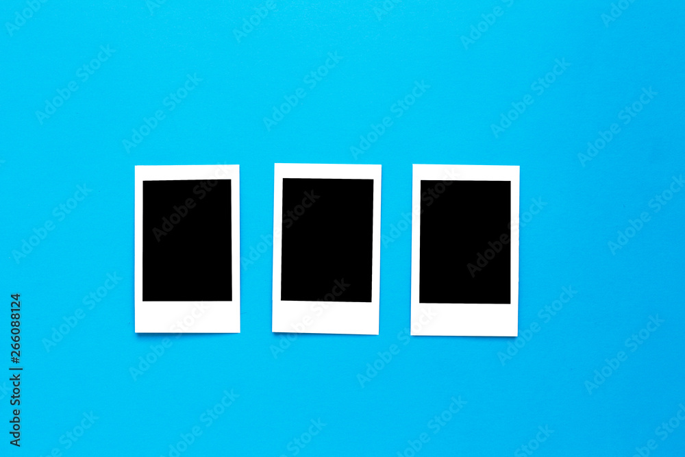 Blue camera with blank picture frames on colourful background. Fashion Film Camera. Nostalgia photography. Top view. Minimal and modern design. Trendy flat lay mockup for bloggers, designers, etc. 