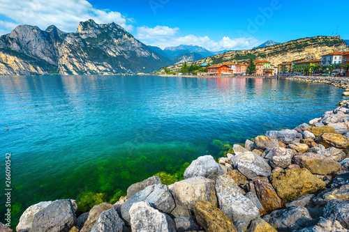Lake shore with rocks and mountains in background, lake Garda
