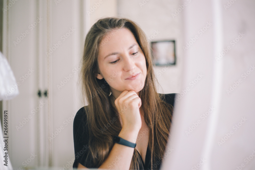 Close-up girl of European appearance thoughtfully sits in front of a mirror in a bright hotel room Close-up girl of European appearance thoughtfully sits in front of a mirror in a bright hotel room