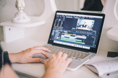 Close-up of female hands working on a laptop in a video editing program