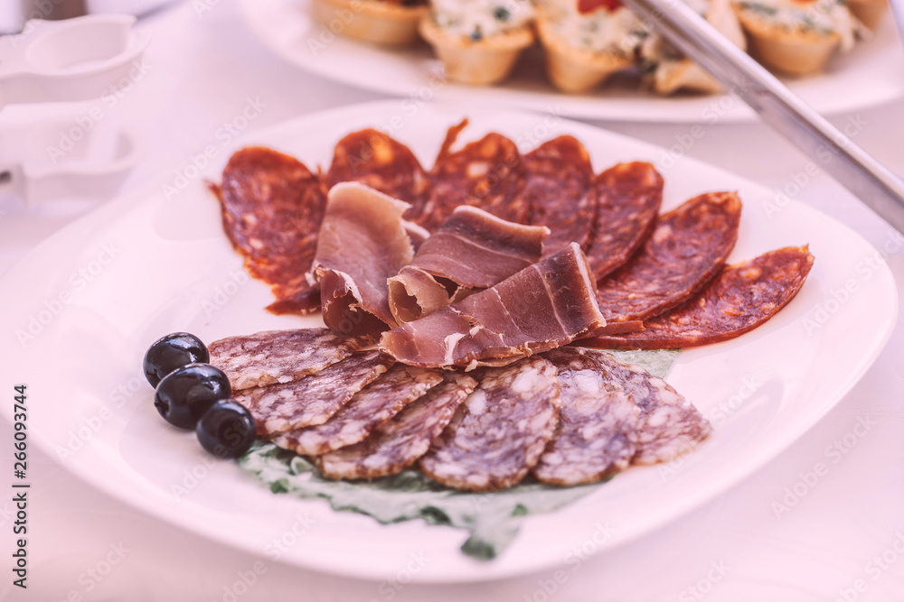 slices of salami and meat on the festival table slices of salami and meat on the festival table