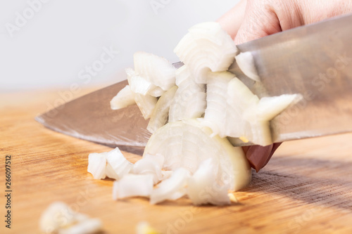 cook cuts onion on a wooden board