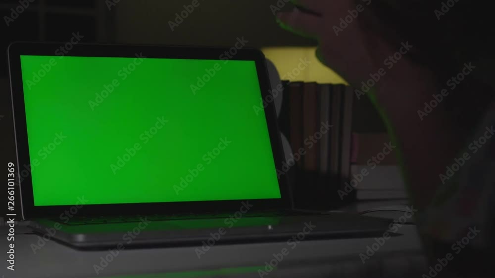 Laptop with green screen. Dark office. Dolly shot. Perfect to put your own image or video. Laptop with green screen. Dark office. Dolly shot. Perfect to put your own image or video.