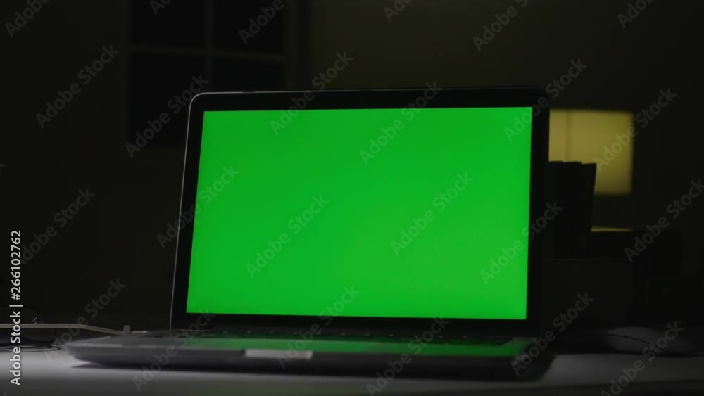 Laptop with green screen. Dark office. Dolly shot. Perfect to put your own image or video. Laptop with green screen. Dark office. Dolly shot. Perfect to put your own image or video.