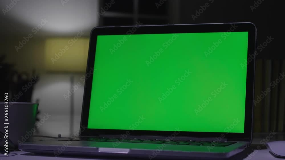Laptop with green screen. Dark office. Dolly shot. Perfect to put your own image or video. Laptop with green screen. Dark office. Dolly shot. Perfect to put your own image or video.
