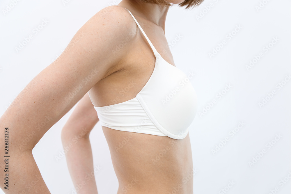 Foto de side view . slim young athletic girl in white lingerie shows her  figure, shows Breasts in bra . isolated on a light background. without  retouching. do Stock