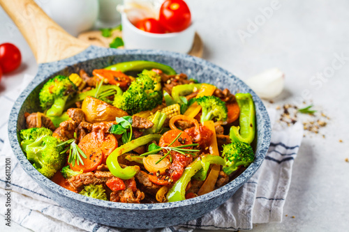 Fried beef stroganoff with potatoes and vegetables in a pan.