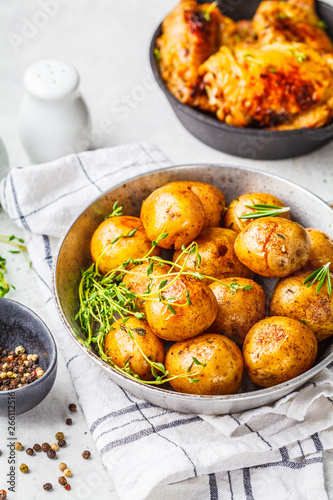 Grilled chicken and baked potatoes in a cast iron skillet.