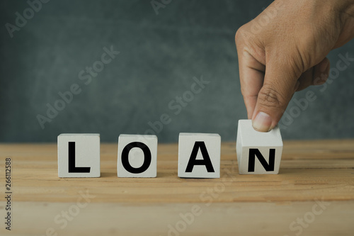 finance and banking concept, Hand putting wooden loan shape on table