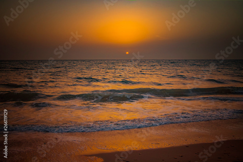 Nature background of amazing beach sunset with endless horizon and incredible foamy waves. It is Atlantic ocean in tropical paradise in Senegal  Africa. There is beautiful golden sun.