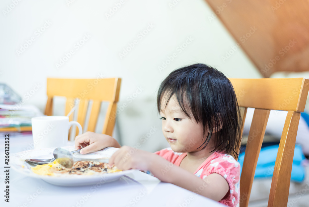 Asian little baby child eating and enjoy breakfast by herself Asian little baby child eating and enjoy breakfast by herself