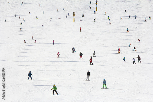 Lots of skiers and snowboarders on the slope at ski resort