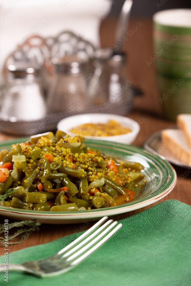 Braised green beans with carrots and mustard in a ceramic plate Braised green beans with carrots and mustard in a ceramic plate