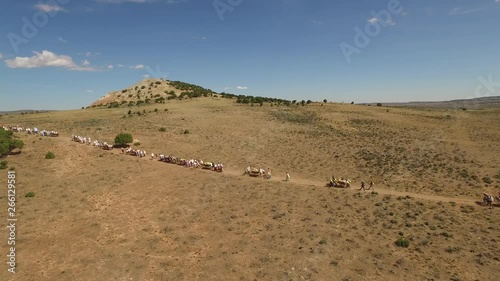 Aerial Of Pioneer Trek Crossing Plains. Aerial clip of a group of people on the pioneer trek. photo