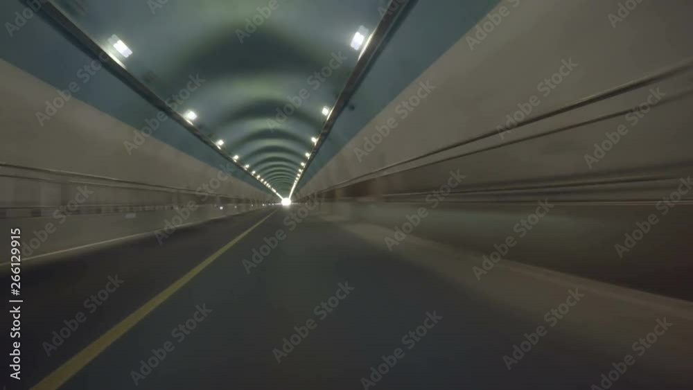Loopable POV entering empty road tunnel then exiting. Going inside tunnel, video loops inside, then coming out the other side. Driving through hillside automobile tunnel underground in countryside.