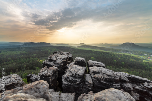 Elbe Sandstone Mountains - panoramic view from the mountain Gohrisch to the west, evening light with sunbeams and light haze, in the foreground sandstone cliffs - Germany, Saxony, Saxon Switzerland