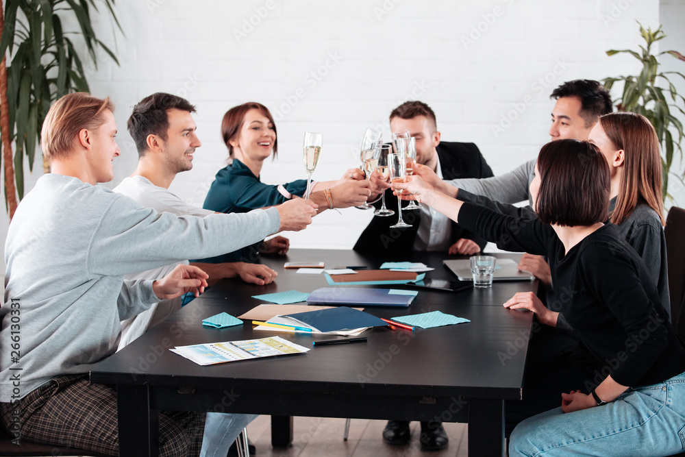 Well done work success young business people toasting each other and smiling while standing in the board room coworking, drink champagne celebrate christmas birthday new year contract