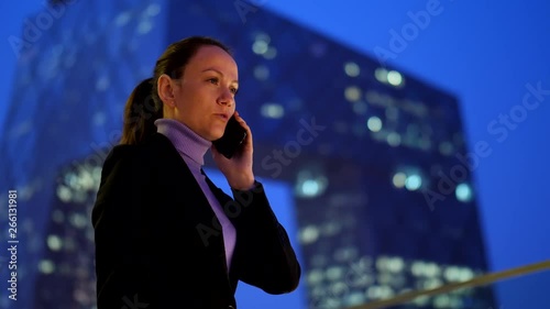Businesswoman talking on cellphone against skyscraper at downtown