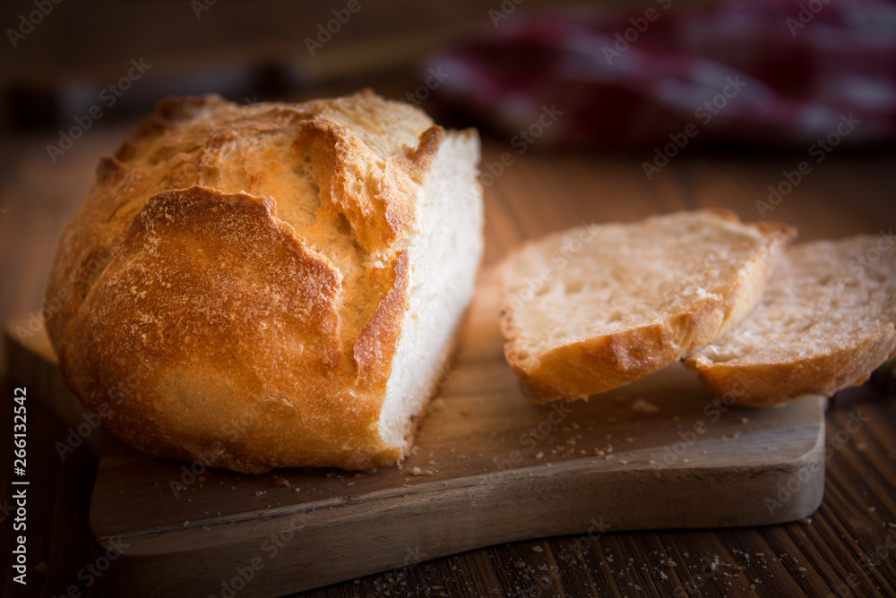 Sliced loaf of wheat bread on wooden table Sliced loaf of wheat bread on wooden table