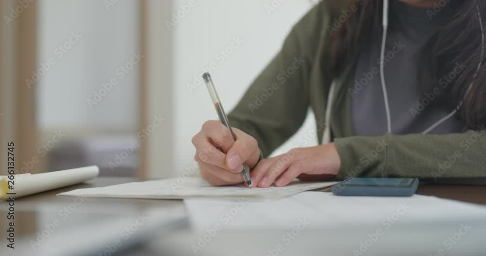 Woman write on the report, study for the exam at home Woman write on the report, study for the exam at home