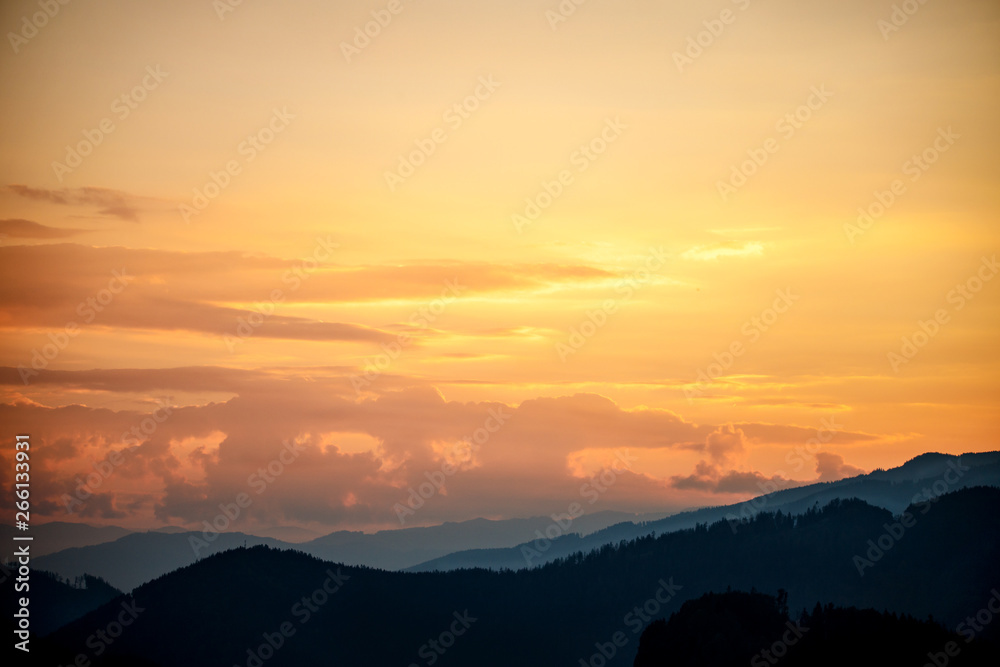 sunset in the austrian alps with silhouette of colorful clouds and mountains in the austrian alps in styria