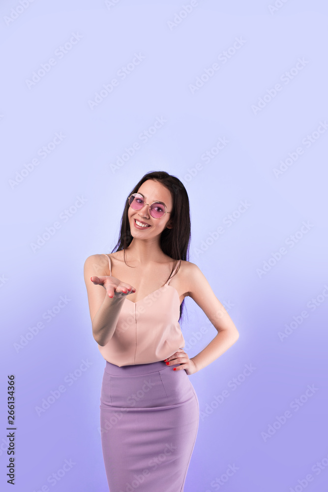 girl on a simple background with an outstretched hand makes an offer girl on a simple background with an outstretched hand makes an offer