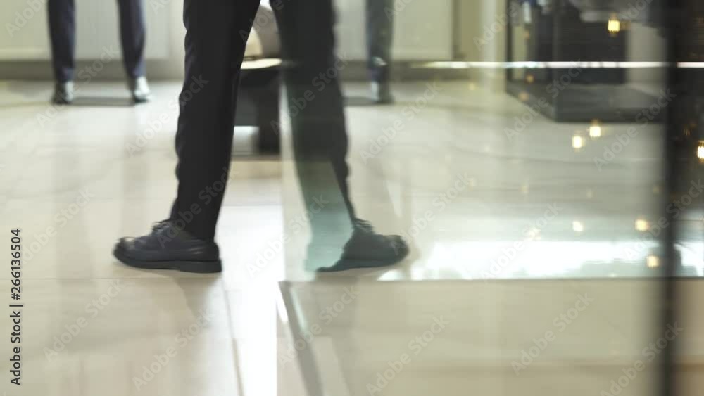 A client walking in showroom of men clothing boutique with stylish interior and looking through male suits. Boutique of brand male clothes A client walking in showroom of men clothing boutique with stylish interior and looking through male suits. Boutique of brand male clothes