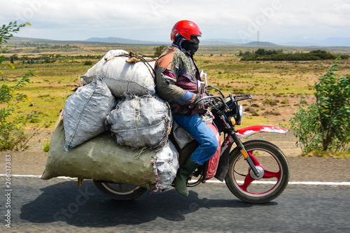 Foto Kenyan humble man riding an oversized bike.