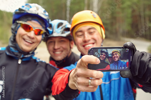 group of cyclists in helmets taking selfie photo. team outdoors