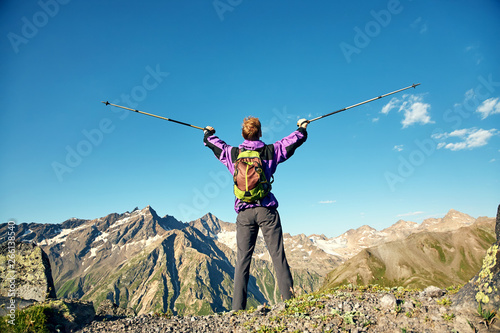 climber on trail in the mountains. a man with a backpack in hike