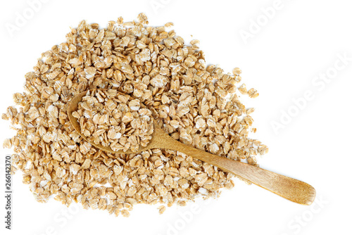 Pile of wheat flakes and wooden spoon