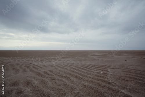 Ground view of sandy beach on cloudy day