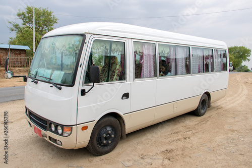 The small bus stands on a stop along the road to Mandalay, Myanmar. White express bus ready for departure, Burma.
