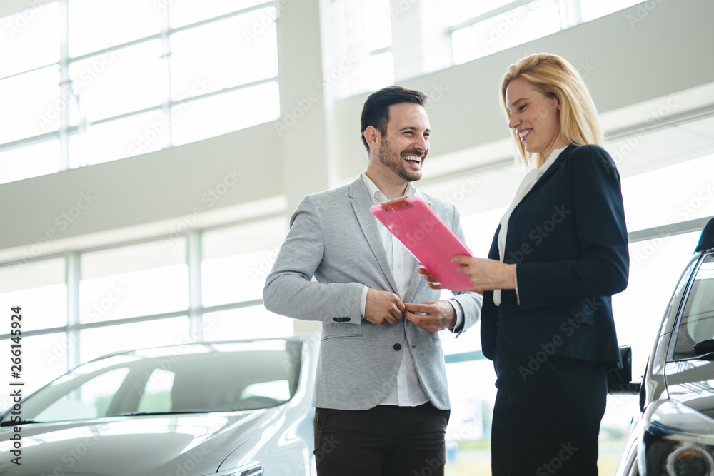 Dealer showing a new car model to the potential customer
