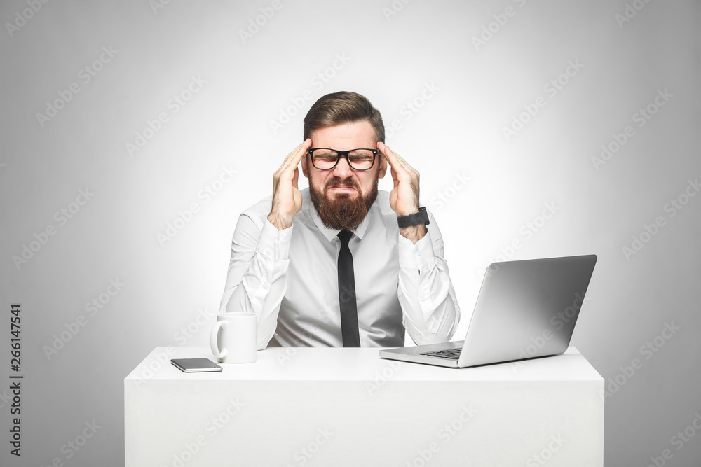 No way! Portrait of emotional upset young manager in white shirt and black tie are sitting in office and grimacing cause made big mistake with stressed face, holding fingers near temples. Studio shot No way! Portrait of emotional upset young manager in white shirt and black tie are sitting in office and grimacing cause made big mistake with stressed face, holding fingers near temples. Studio shot