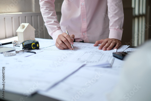 architect engineer working on house blueprint of real estate project at workplace. construction & building concept