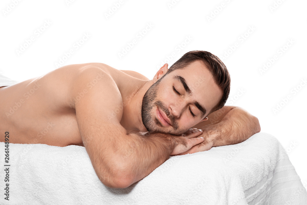 Handsome man relaxing on massage table against white background. Spa service Handsome man relaxing on massage table against white background. Spa service