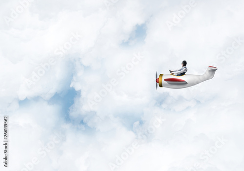 Man in aviator hat driving propeller plane