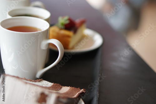 Chocolate Cake and cheese cake with strawberry on plate. Cup of tea during evening English tea time. Selective focus photo